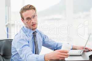 Tired businessman waking up with coffee cup