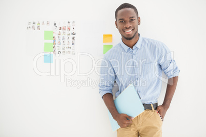 Smiling businessman standing and holding file