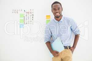 Smiling businessman standing and holding file