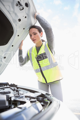Upset woman checking her car engine