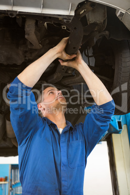 Mechanic examining under the car