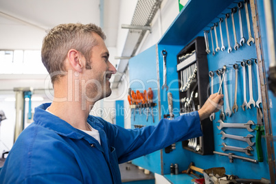 Mechanic taking a tool from wall