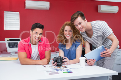 Smiling students working with camera and tablet