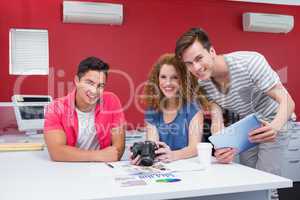 Smiling students working with camera and tablet