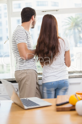 Young couple looking out their window