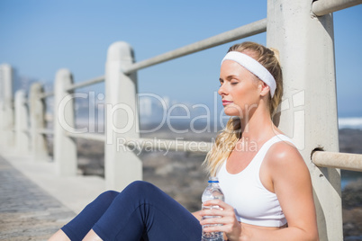 Fit blonde sitting on the pier