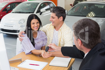 Salesman giving key to a smiling couple