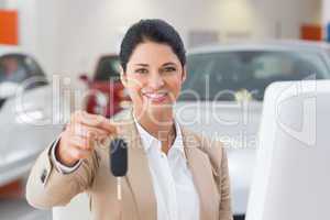 Smiling saleswoman giving a customer car key