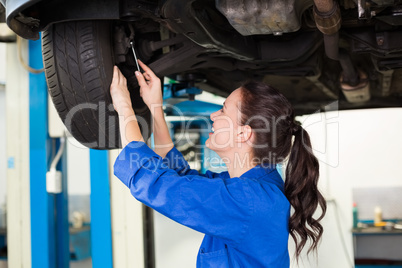 Smiling mechanic adjusting the tire