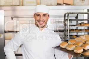 Happy baker showing tray of fresh bread