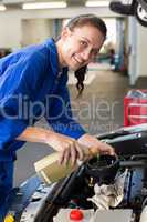 Mechanic pouring oil into car