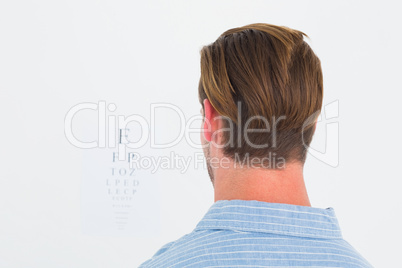 Focused man in suit on eye test letters