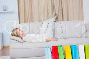 Blonde lying on couch getting headache