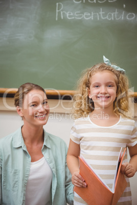 Cute pupil smiling at camera during class presentation