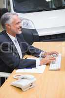 Cheerful businessman typing on laptop