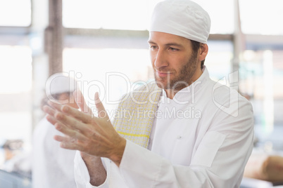 Baker clapping flour from his hands