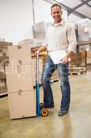 Delivery man leaning on trolley of boxes