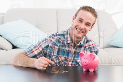 A smiling man holding a pennie