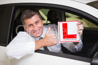 Man gesturing thumbs up holding a learner driver sign