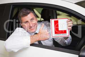 Man gesturing thumbs up holding a learner driver sign