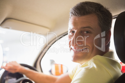 Man sitting on a car while looking at camera