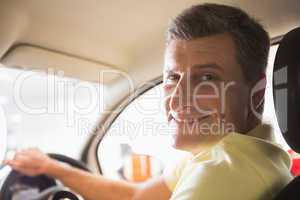 Man sitting on a car while looking at camera