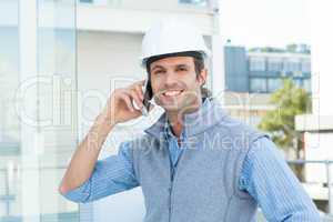 Smiling male architect using mobile phone outdoors