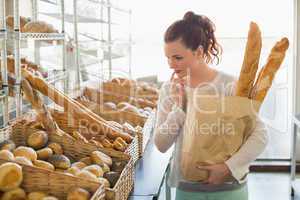 Pretty brunette holding bag of bread