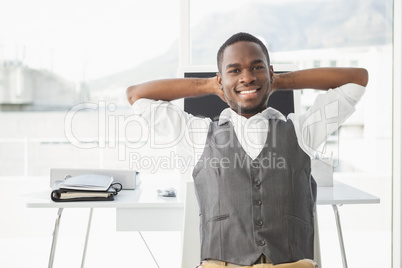 Relaxed businessman with hands behind head