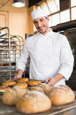 Happy baker taking out fresh bagels