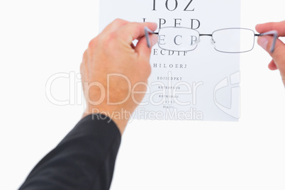 Man holding eyeglasses over paper