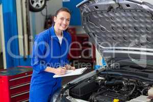 Mechanic examining under hood of car