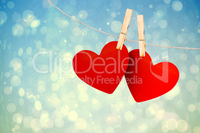 Composite image of hearts hanging on line