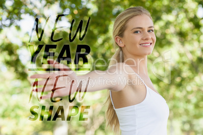 Composite image of young fit woman doing yoga in a park spreadin