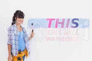 Composite image of woman painting wall blue and smiling