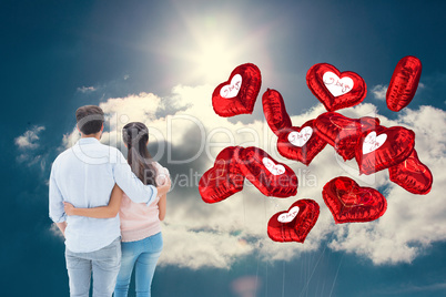 Composite image of attractive young couple standing with arms ar