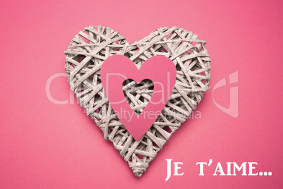 Composite image of wicker heart ornament with paper cut out