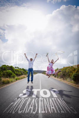 Composite image of excited couple jumping on the road