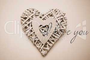 Composite image of wicker heart ornament with paper cut out