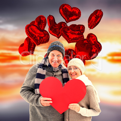 Composite image of happy mature couple in winter clothes holding