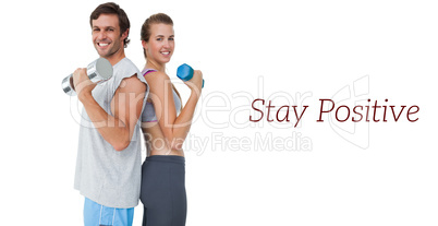 Portrait of a fit couple exercising with dumbbell