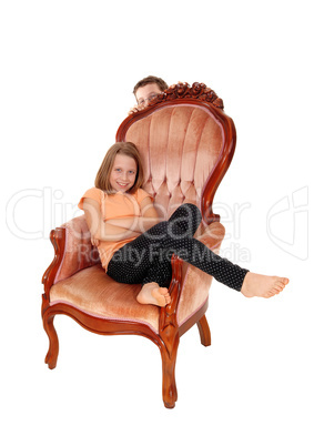 Young girl in pink armchair.