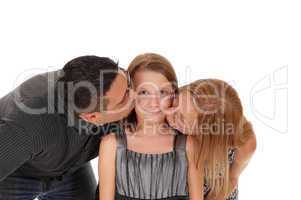 Parents kissing there daughter.