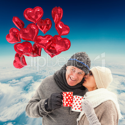 Composite image of happy mature couple in winter clothes holding