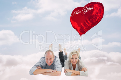 Composite image of happy mature couple lying and smiling