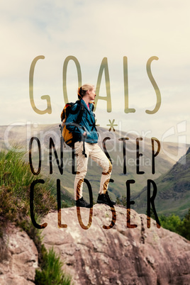 Composite image of woman standing on rock admiring the view