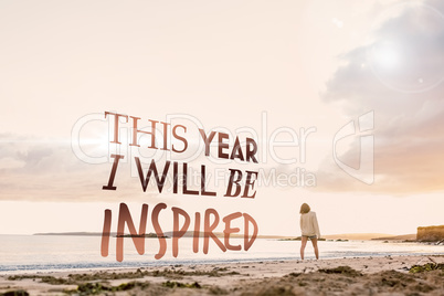 Composite image of woman in sweater walking on beach