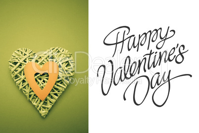 Composite image of wicker heart ornament with green paper cut ou