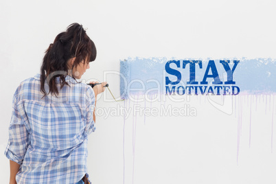 Composite image of woman painting wall blue