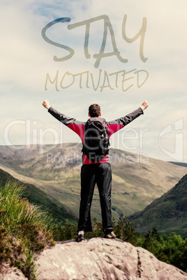 Composite image of man standing at hill top cheering